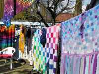 Färgglada små och stora handstickade rutor på ponchos och sjal. textilkonstnär katrin bawah.